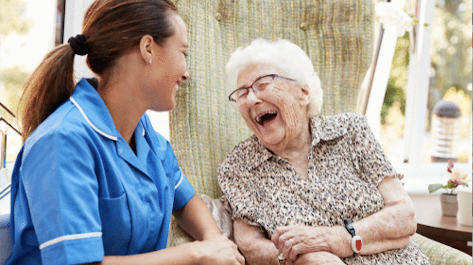 nurse with elderly senior woman who is laughing